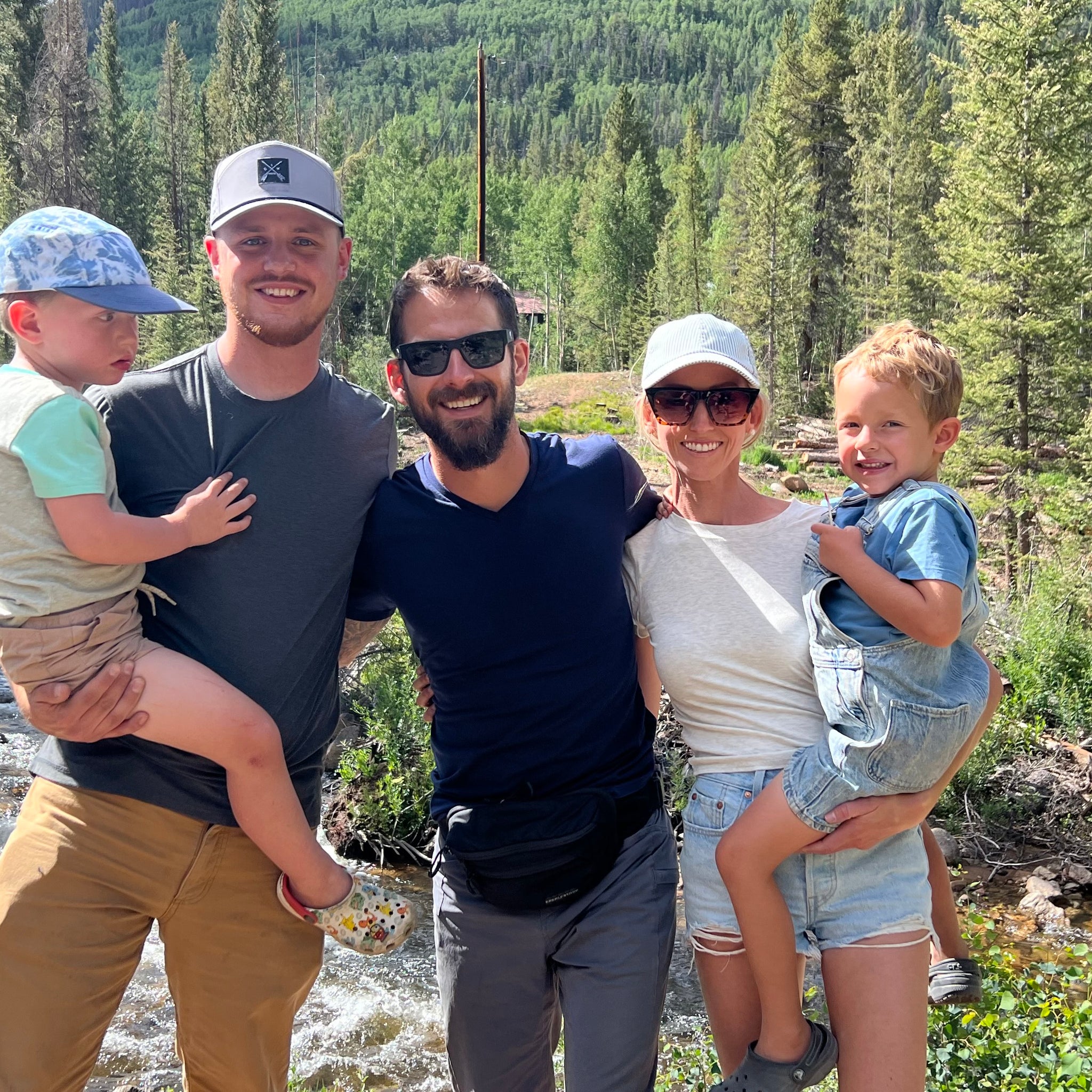 Nut Ruck Founders and their families standing in front of a river in a pine forrest in the mountains